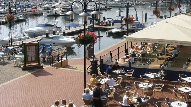 A marina with boats docked, outdoor seating, and a sign for 'Harbour Boat Trips'. - Peaceful Retreat, Sovereign Harbour, Eastbourne - FREE WELCOME PACK (Eastbourne)