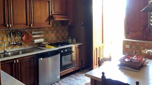 Cucina con mobili in legno, fornello, forno e lavastoviglie.