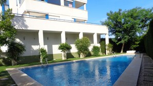 Une piscine rectangulaire à l’eau d’un bleu limpide, bordée d’une margelle en pierre.