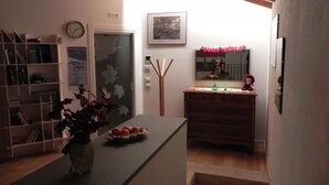 Eine moderne Küche mit dunkler Arbeitsplatte, einer Vase mit roten Blättern und einer Uhr an der Wand.