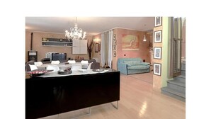 Un salon moderne comprenant un coin repas, un lustre et un escalier menant à l’étage supérieur.