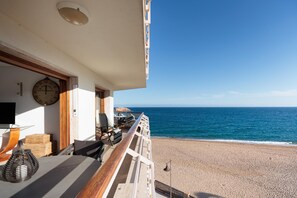 A balcony with a view of the sea, a clock, and a bar area.