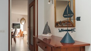 Uma secretária de madeira com um modelo de veleiro, um relógio de parede e um espelho decorado com um veleiro.