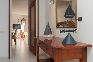 A wooden desk with a sailboat model, a wall clock, and a mirror with a sailboat decoration. - INCREDIBLE APARTMENT WITH AMAZING VIEWS (Tossa de Mar)
