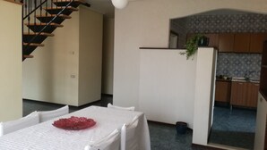 Een hotelkamer met een eethoek, een keuken en een trap.