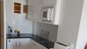 A compact kitchen with white cabinets, a black countertop, a microwave, and a toaster. - Studio apartment With Shared Pool, Garden And Kiosk Serving alcohol & ices/sweet (Benalmádena)