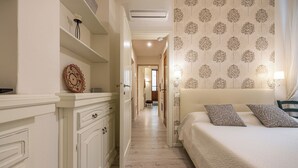 A bedroom with a bed, bedside lamps, and a patterned wall. - Marco's Stylish Home: in the hearth of Cagliari (Cagliari)