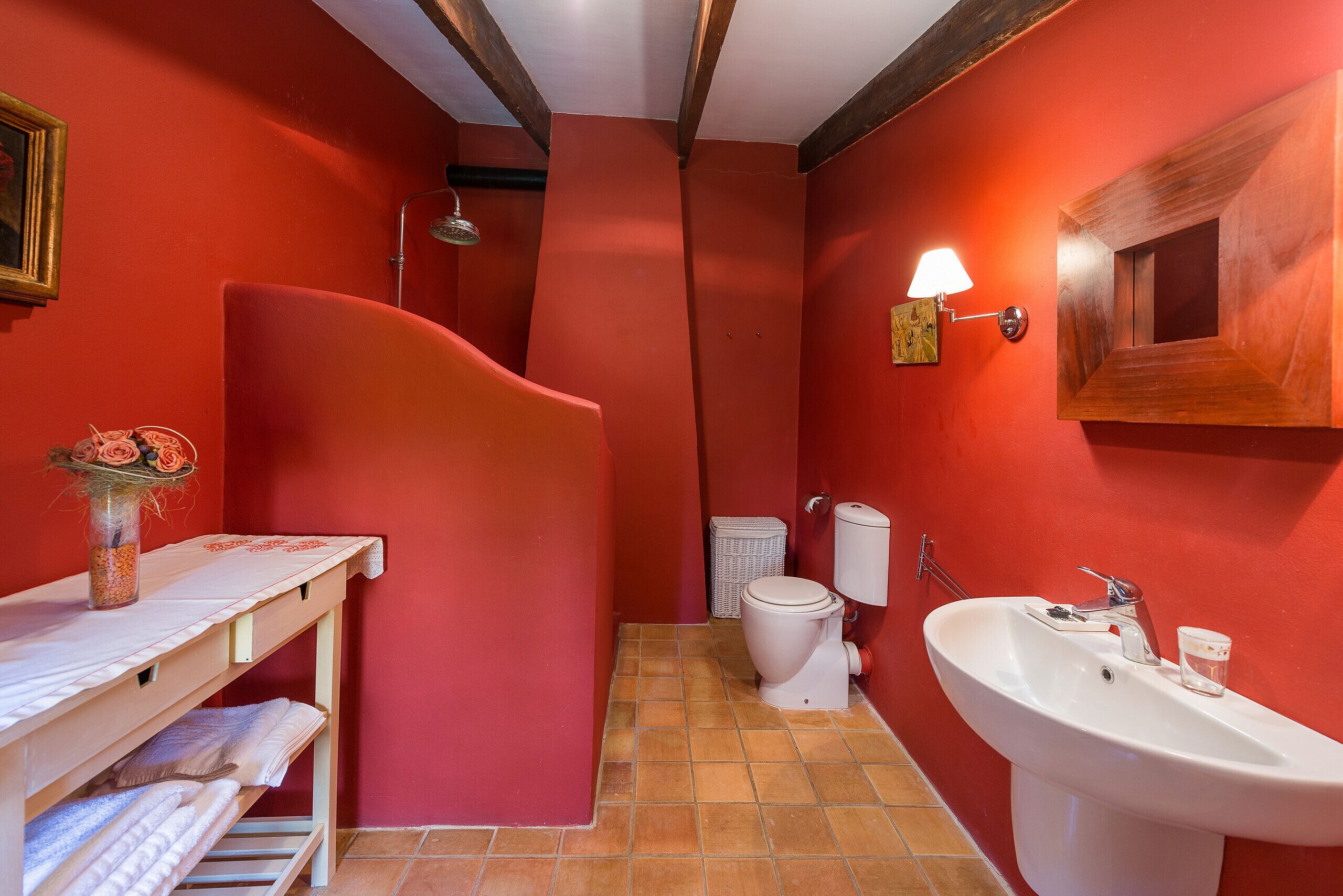 A bathroom with red walls, a white sink, and a toilet.