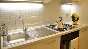 A kitchen with a stainless steel sink, a gas stove, and a built-in oven.