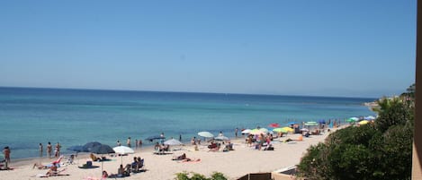 Una playa cerca, sillas reclinables de playa, toallas de playa