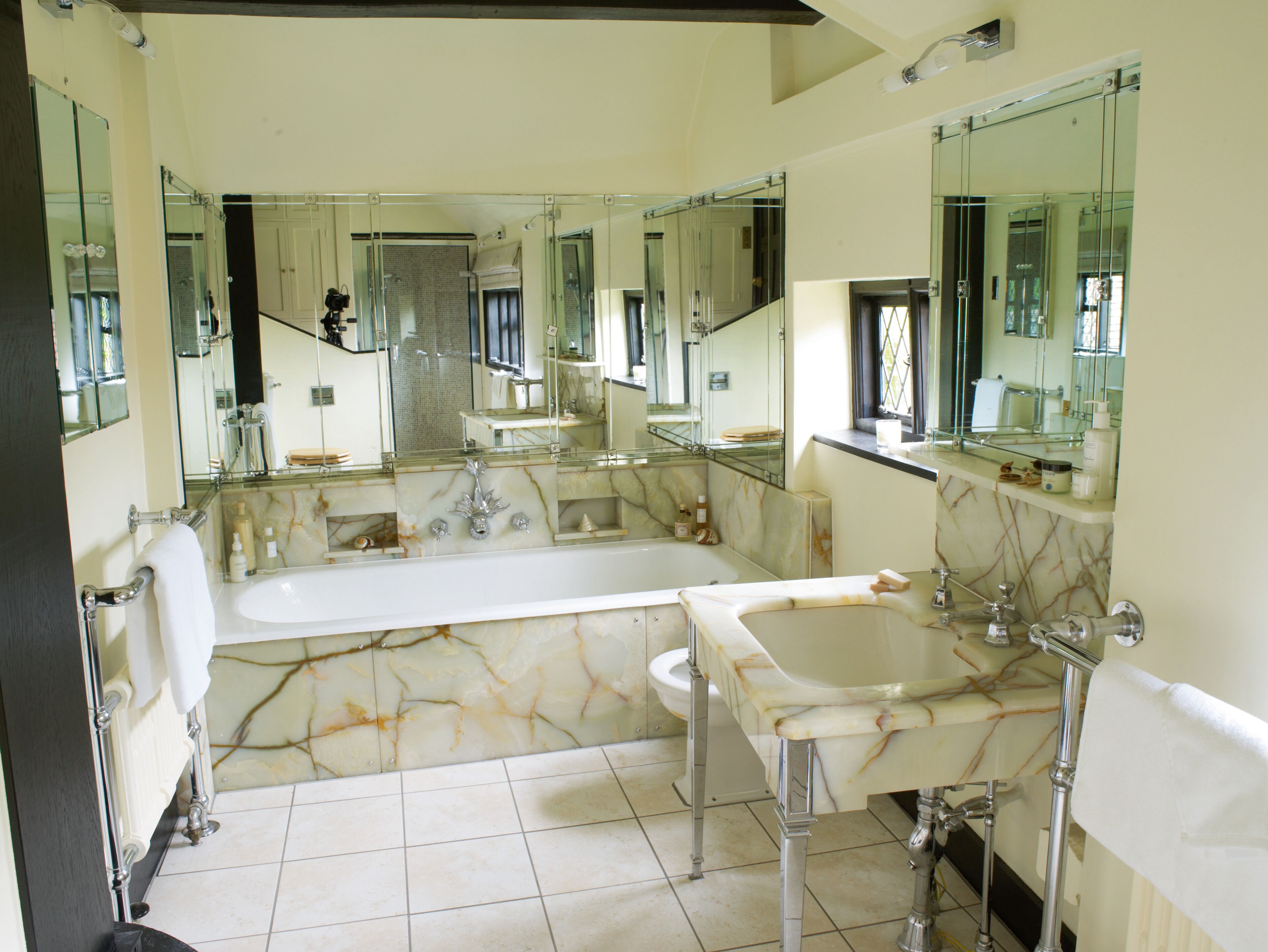 A spacious bathroom with a large bathtub, two sinks, and multiple mirrors.