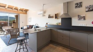 Una cocina moderna con una isla grande, taburetes de bar y vistas a las montañas.