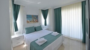 Een hotelkamer met een bed, nachtkastje, schilderij en gordijnen.