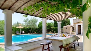 An outdoor patio with a pool, a table with a tablecloth, and a pergola with vines. - CAL REI  Ref. VP34 (Pollensa / Pollença)