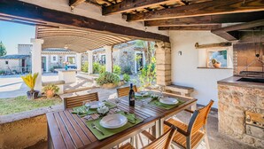 An outdoor dining area with a stone wall, wooden beams, and a view of the street. - CAL REI  Ref. VP34 (Pollensa / Pollença)