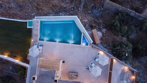 An aerial view of a property with a swimming pool, outdoor seating area, and a covered patio. - THETIS, south coast with amazing views and infinity pool! (Chania)