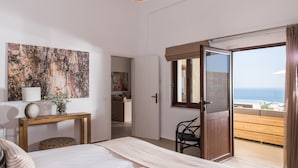 A bedroom with a large bed, a wooden console table, a painting, and a view of the sea through an open door. - THETIS, south coast with amazing views and infinity pool! (Chania)