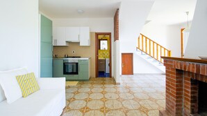 A compact living space with a kitchenette, a staircase, and a fireplace. - Holiday home on the amazing Cilento Coast in the south of Italy (Case del Conte)