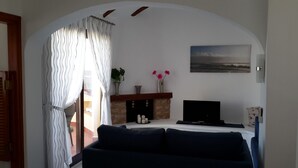 A living room with a fireplace, a sofa, and a TV. - Inviting, bright 2-Bedroom El Rancho villa in prestigious La Manga Club Resort (La Manga Club)