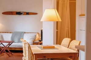 A dining area with a table, chairs, and a hanging lamp. - ApartmentsTamariu#5 🌊 Cozy Retreat with Terrace (Tamariu)