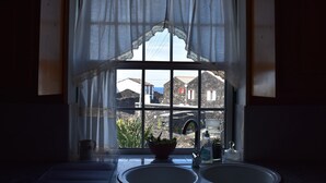 Eine Küche mit Fenster, Spüle und einer Topfpflanze.