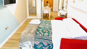 A compact hotel room with a bed, a desk, and a mirror. - SuiteCorso Vibo Valentia (Vibo Valentia)