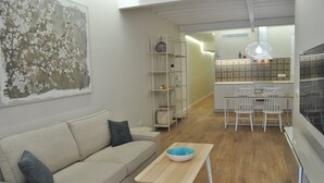 A modern living room with a beige sofa, a wooden coffee table, and a white dining area with chairs. - Cream Homes La Rambla, INTERIOR TOURISM Accommodation (Palma)