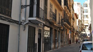 A narrow street lined with multi-story buildings, featuring balconies and shutters. - Cream Homes La Rambla, INTERIOR TOURISM Accommodation (Palma)