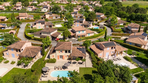 Zona residencial con casas, piscina y jardín bien cuidado.