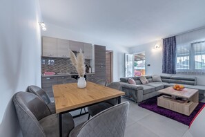 Relax in this stylish living space with a dining table, sofa, and armchair, perfect for unwinding.