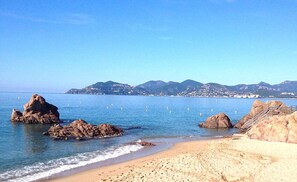 A beach with rocky formations and a clear view of distant mountains. - MyHome Riviera Apartments - Cannes Rentals (Cannes)