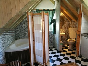 A bathroom with a checkered floor, a bathtub, a toilet, and a shower area.