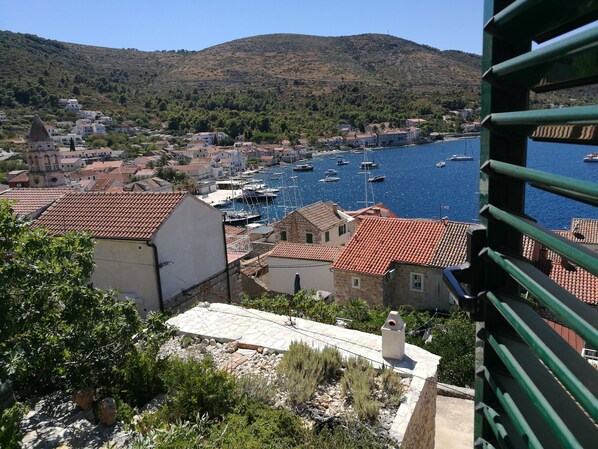 A coastal town with traditional architecture, a marina with boats, and a mountainous backdrop.