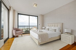 Relax in this serene bedroom with a large bed, bedside table, and city view.
