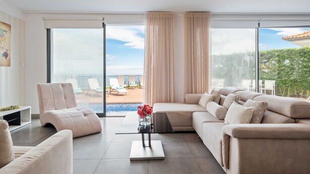 Ein modernes Wohnzimmer mit einer Couch, einem Sessel und einem Couchtisch.