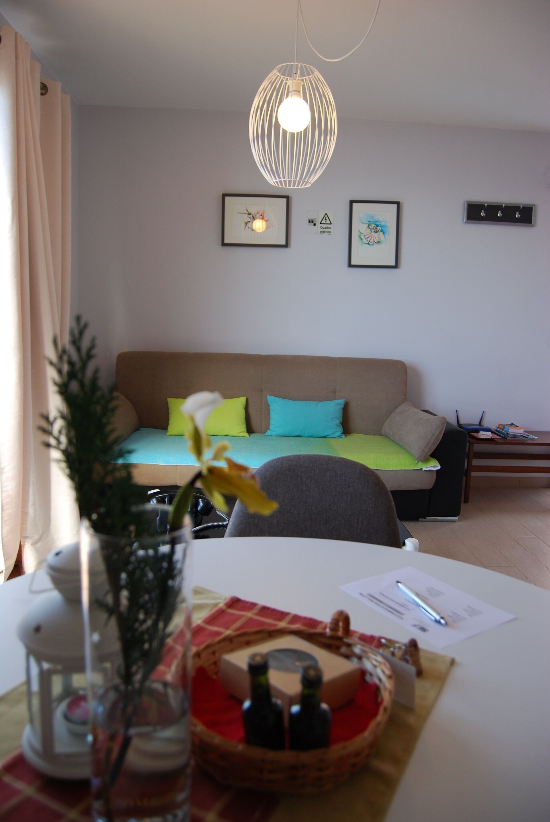 Un accogliente soggiorno con un divano, un tavolo da pranzo con un cesto e una lampada a sospensione.