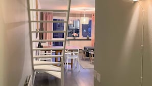 Un interior moderno con una escalera que lleva a un comedor.