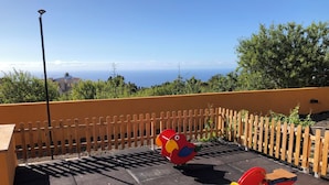 Un parque infantil con una cerca de madera, una farola y vistas al océano.