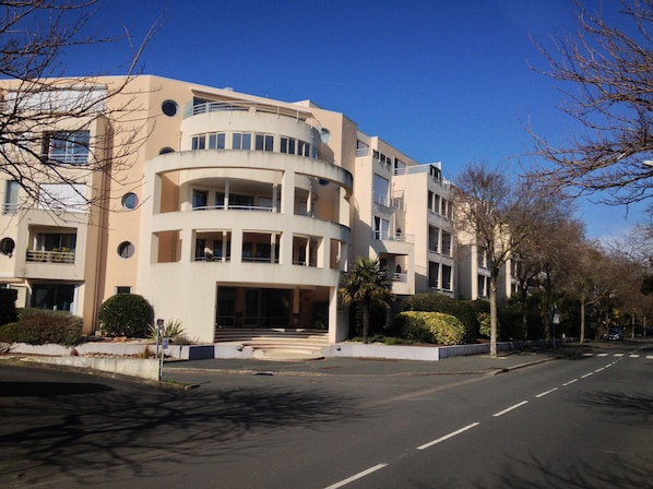 A multi-story building with a curved facade, large windows, and a central entrance.