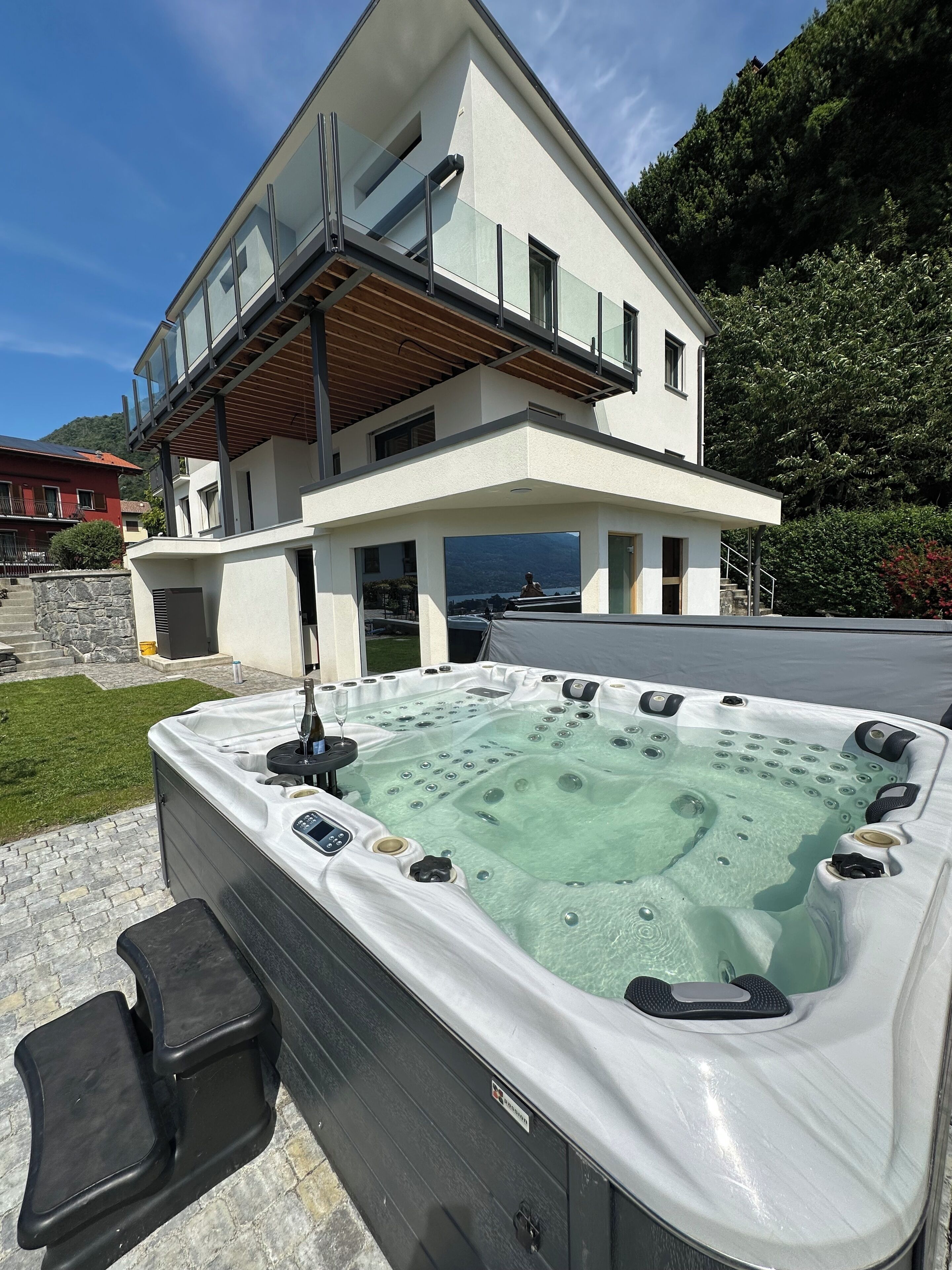 A modern two-story house with a hot tub in front.