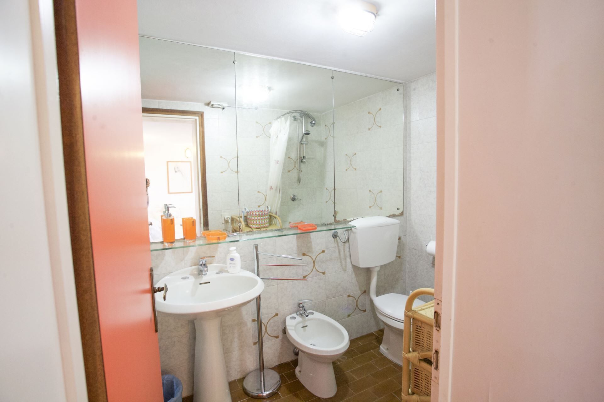 Une salle de bain avec une douche à parois de verre, un lavabo blanc, un bidet et des toilettes.