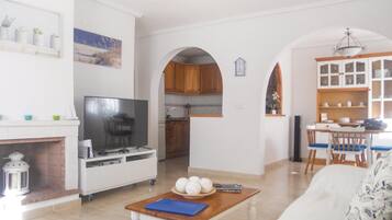 Een smart-tv, een open haard, boeken en een kantoor