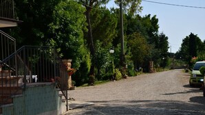 Une rue pavée avec une voiture verte garée sur le côté droit.