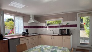 A compact kitchen with a gas stove, microwave, and sink.