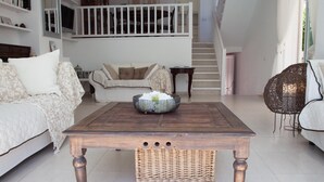 A living room with a wooden coffee table, a sofa, and a wicker chair.