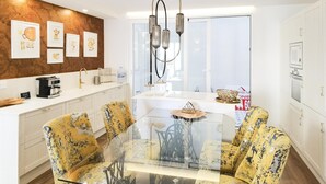 A modern kitchen with white cabinets, a glass dining table, and yellow patterned chairs. - A la luna de Valencia, 4-6 pax, 2 Bedrooms & 2 Bathrooms in downtown Valencia (Valencia)