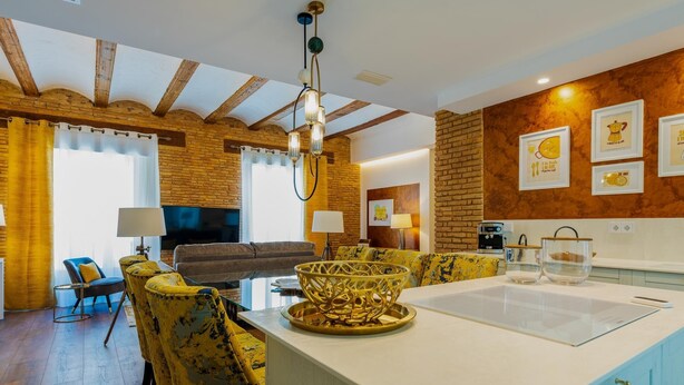 A modern kitchen with a central island, yellow chairs, and a brick wall. - A la luna de Valencia, 4-6 pax, 2 Bedrooms & 2 Bathrooms in downtown Valencia (Valencia)