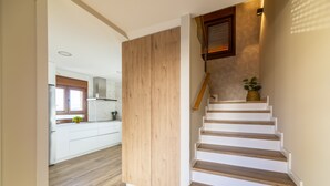 Une cuisine moderne avec des meubles blancs et un plancher en bois.