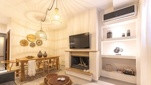 A modern living room with a fireplace, television, and decorative items on shelves. - IO.DELUXE 2ΒR, 2 BTHR.VILLA WITH PRIVATE POOL  AND STUNNING SEA VIEWS  (SKIATHOS)