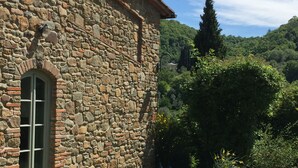 A stone building with a window and a door, a table with a white tablecloth, and a chair. - Relaxing and stilish home only 30 minutes from Florence in Chianti Region (San Polo in Chianti)